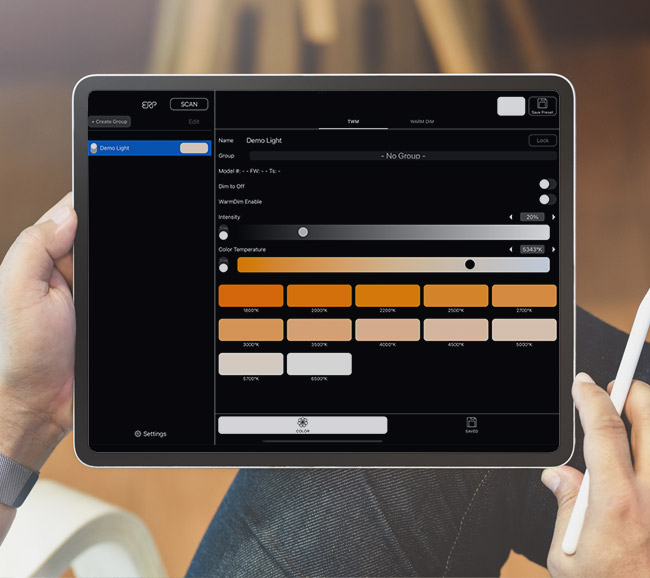 ERP Tunable White App A person is holding a tablet showing the ERP LED light programming software on the screen.