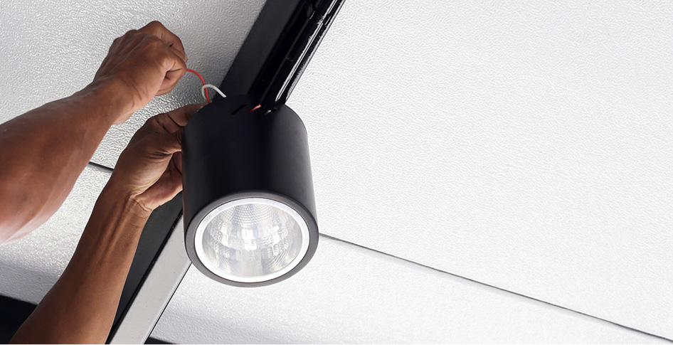 worker installing a light fixture