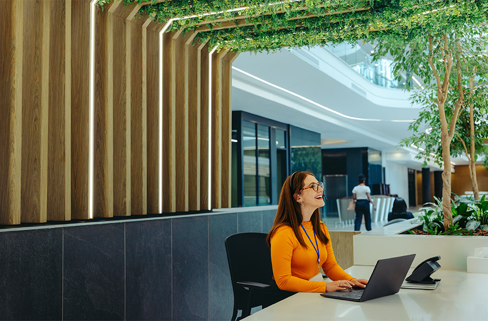 Woman working under LED lighting with greenery on the ceiling.